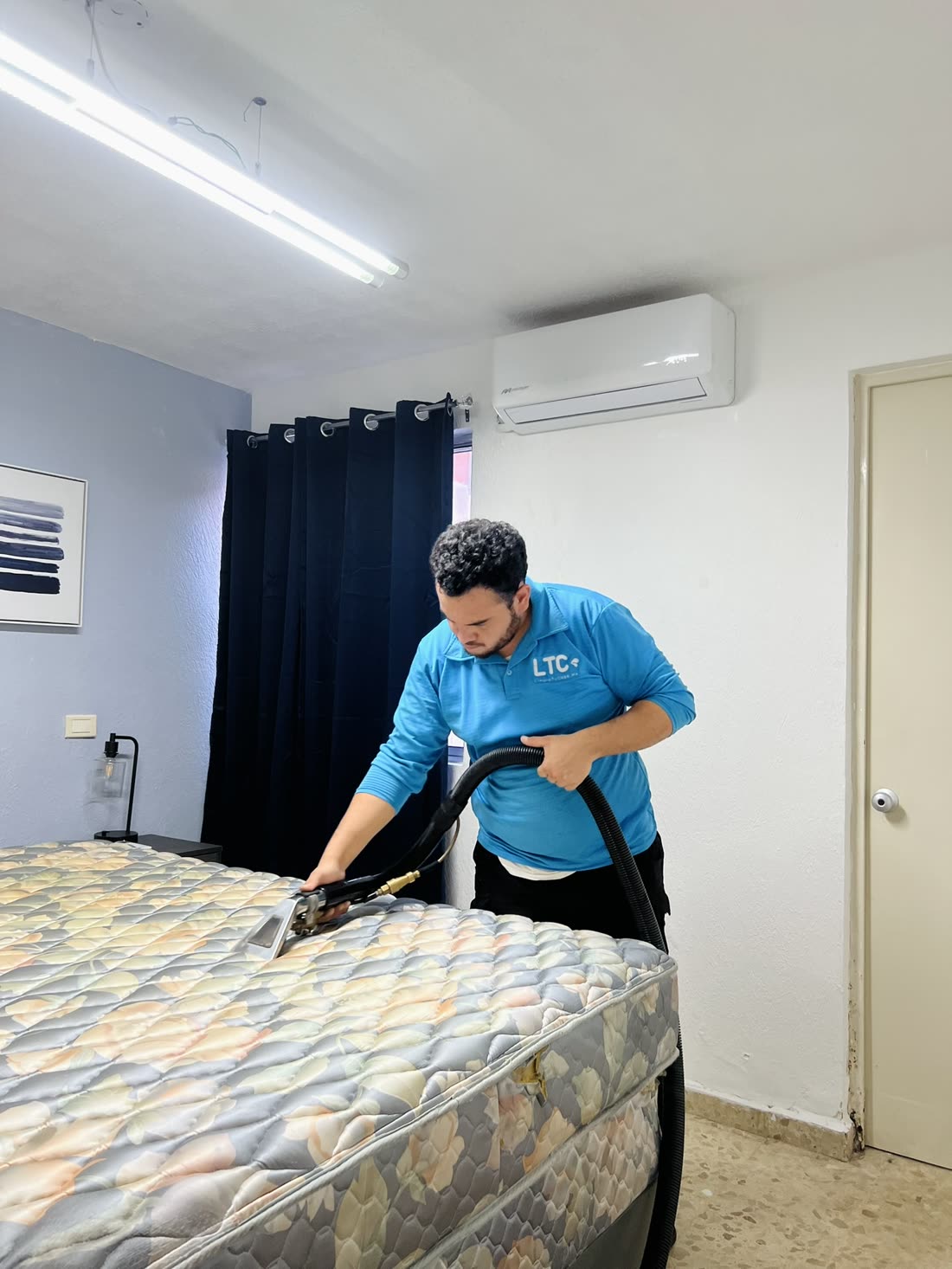 Técnico de LTC lavando un colchón a domicilio con equipo de inyección-succión